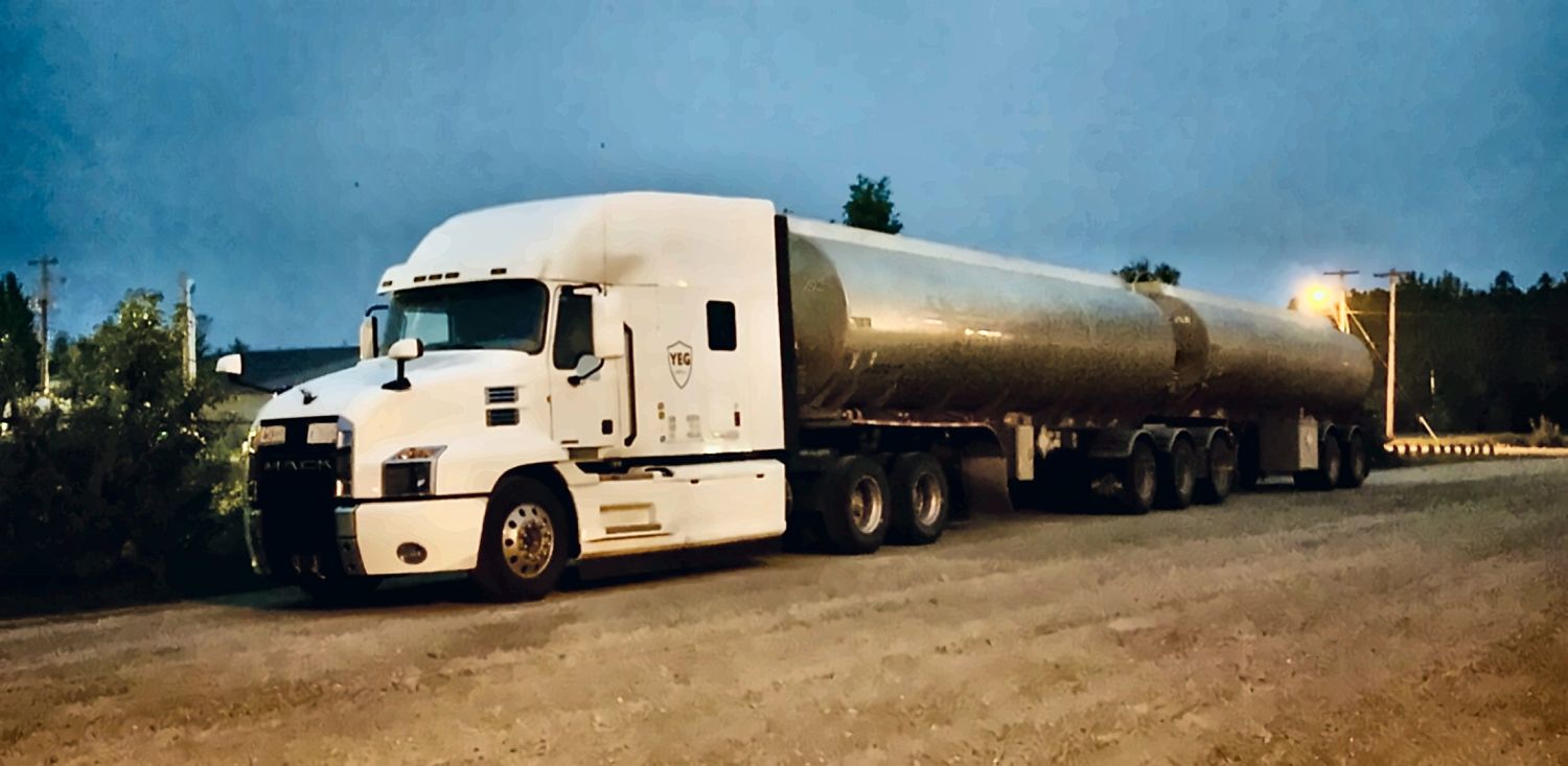 White YEG Logistics Super-B fuel tanker truck parked at dusk